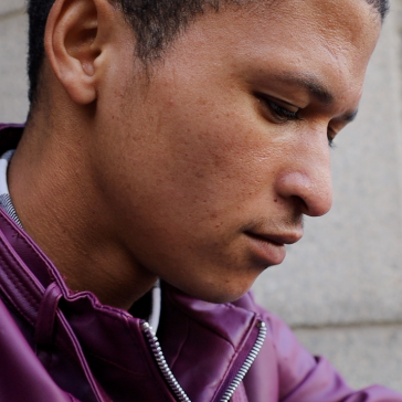 man with quiff and brown tinted sunglasses wearing a fur collar