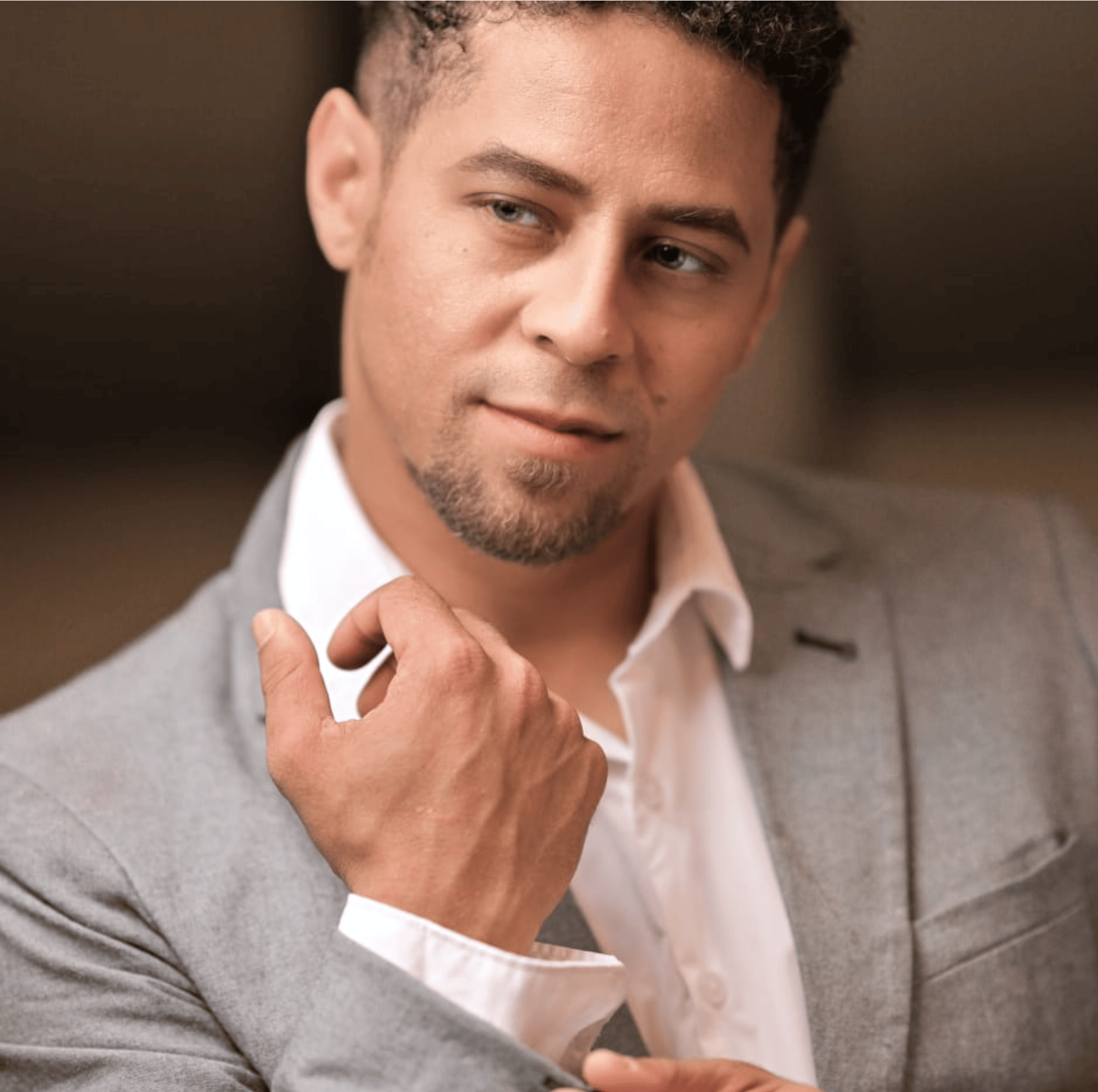 Young man with dark hair and beard, brown eyes, blue t-shirt